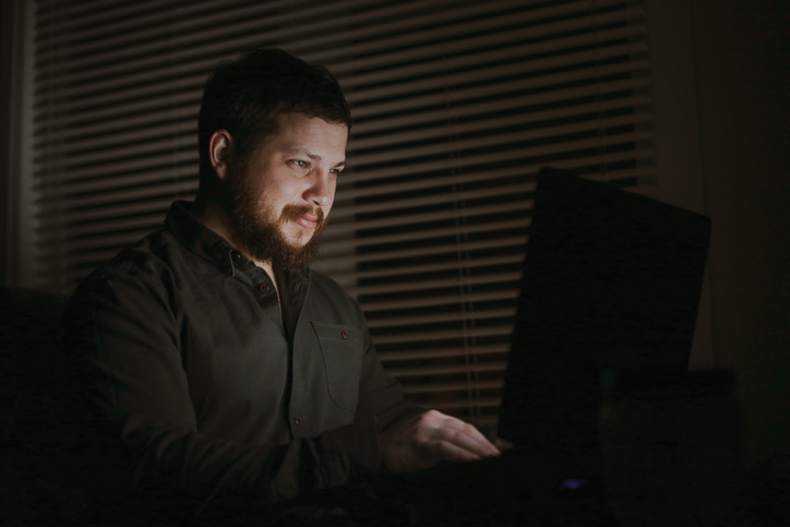Portrait of confident European businessman working with laptop in evening