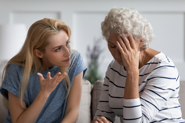 Family sit on couch having dispute, grown up daughter proves her right aggressively argue with elderly mother, 60s mom in despair due to misunderstanding. Generational gap, conflicts at home