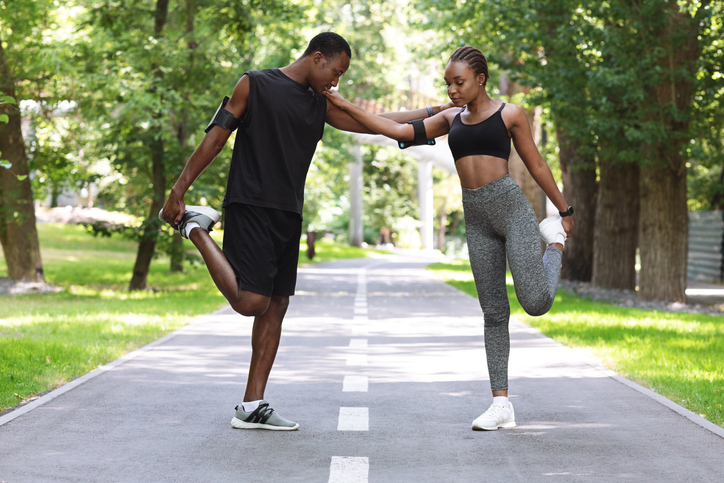 Couple Workout. Fit African Couple Doing Fitness Training Together In City Park, Supporting Each Other During Stretching Leg Muscles Outdoors