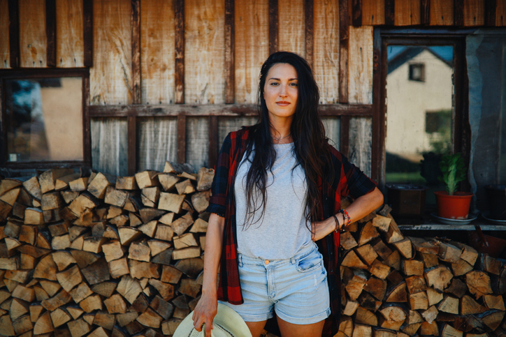woman working at a farm, wood logs