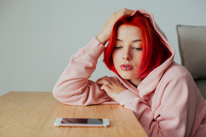 Teen girl waiting for a text message on her phone.
