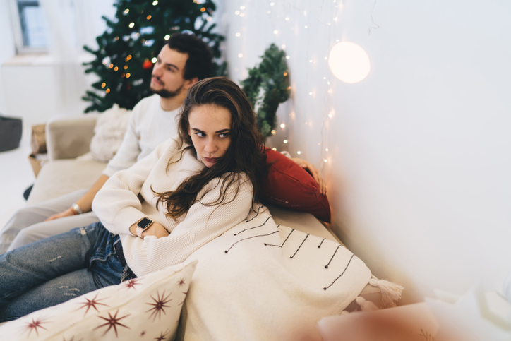 Angry girl looking away having trouble with boyfriend during Christmastime. 
