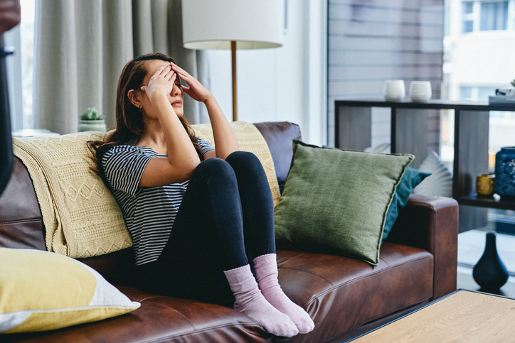 Shot of a young woman looking stressed, worried and tired while sitting at home