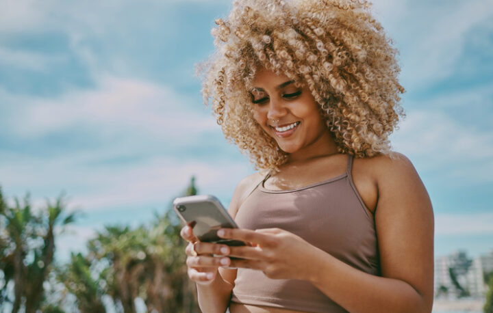 Shot of a young woman using a phone in the city