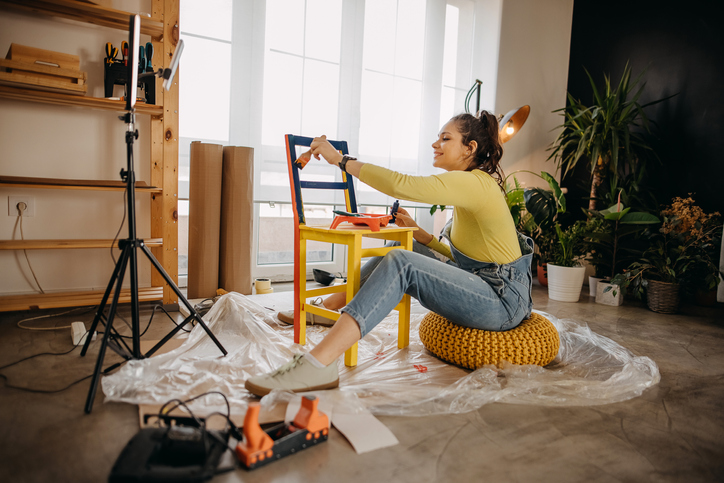 Woman vlogging about repairing old furniture at home