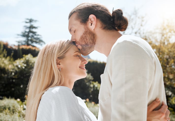 An affectionate couple standing outside