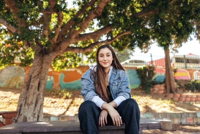 Self confident teenage girl sitting outside