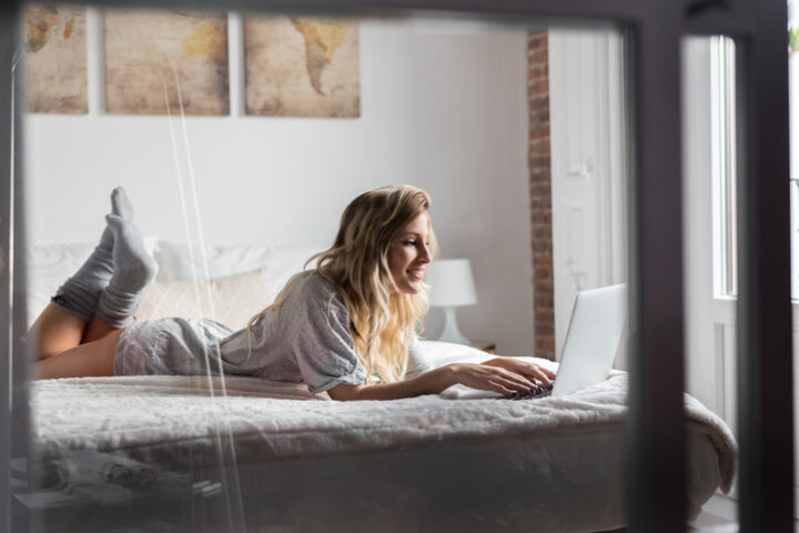 Young woman on bed with her computer.