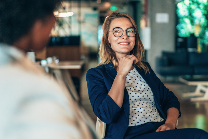 Middle aged businesswoman in a conversation with a colleague. Lawyer consulting client during formal meeting. Job interview and hiring process. Diverse colleagues discussing project concept