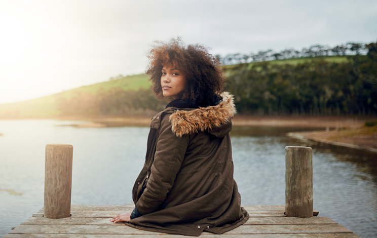 Woman sitting by a lake in nature in quiet contemplation