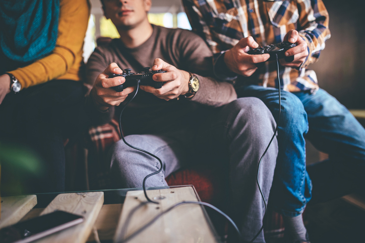 Group of three friends playing video games.