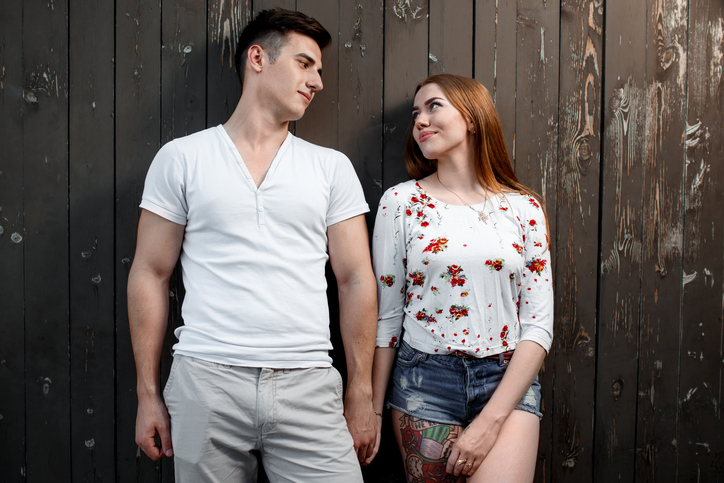 Portrait of young modern couple in love, posing outdoors in city street.