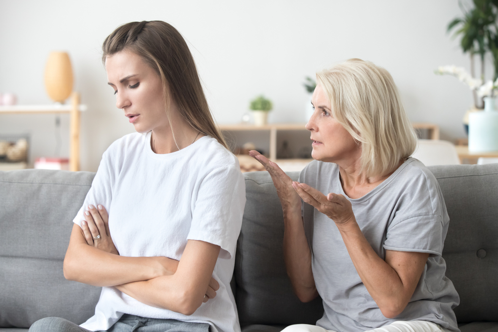 An upset young lady with her back turned against an older woman