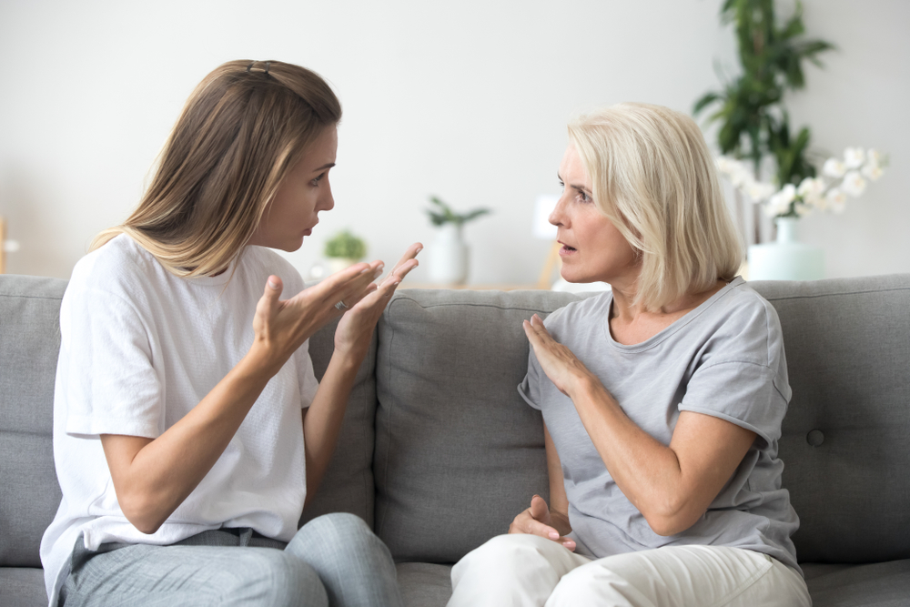 Angry young woman is quarrelling with her mother