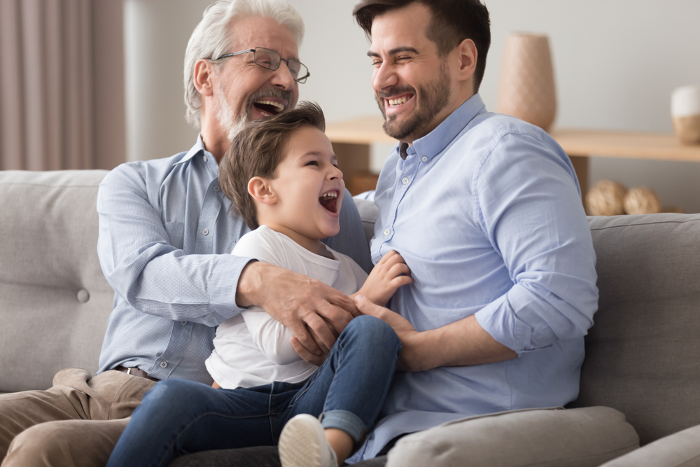 Three generations of smiling men with grandfather, father and child.