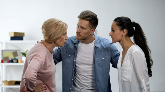 Tw women are having a disagreement and there is a man between them