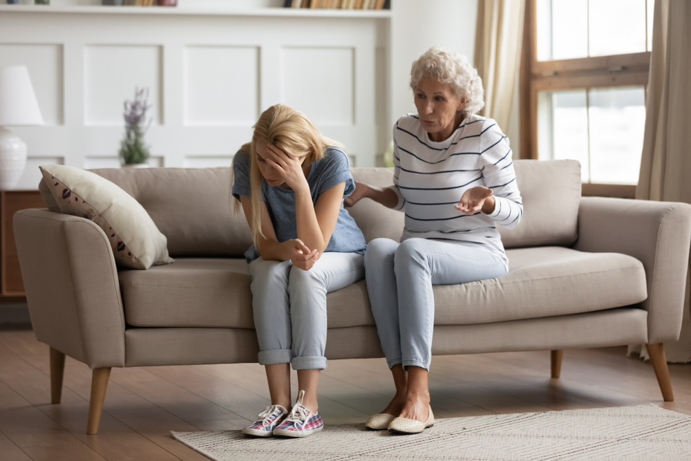 A stressed millennial daughter ignoring her senior mother