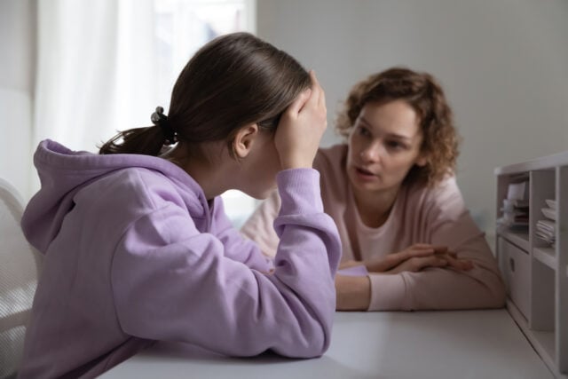 A strict mother scolding her daughter at home