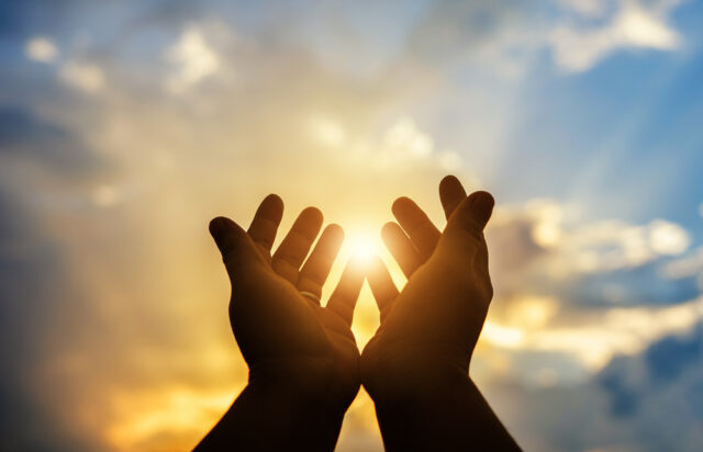 Human hands praying to the sky, spiritual