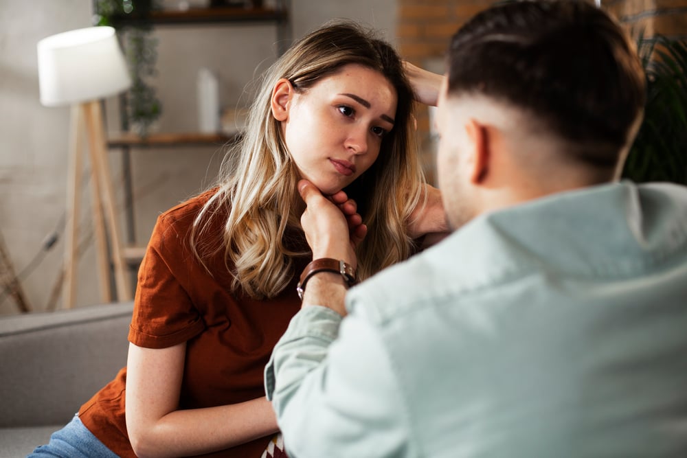 A young woman is having problems and a bad day, and her boyfriend is comforting her
