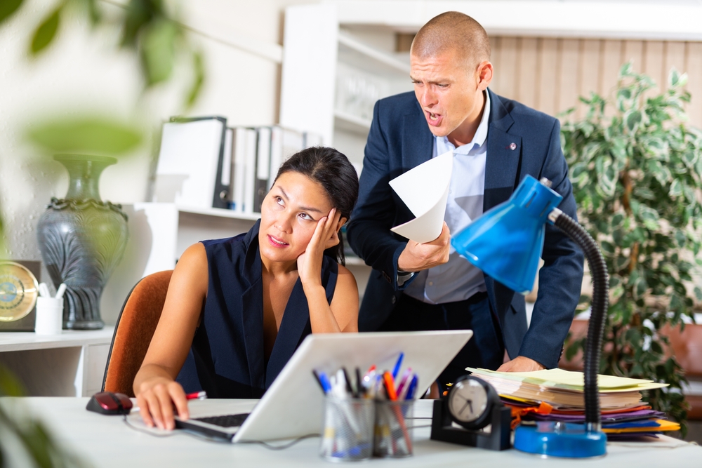 A boss making a demand from his female employee, she turns her back to him and disregards him