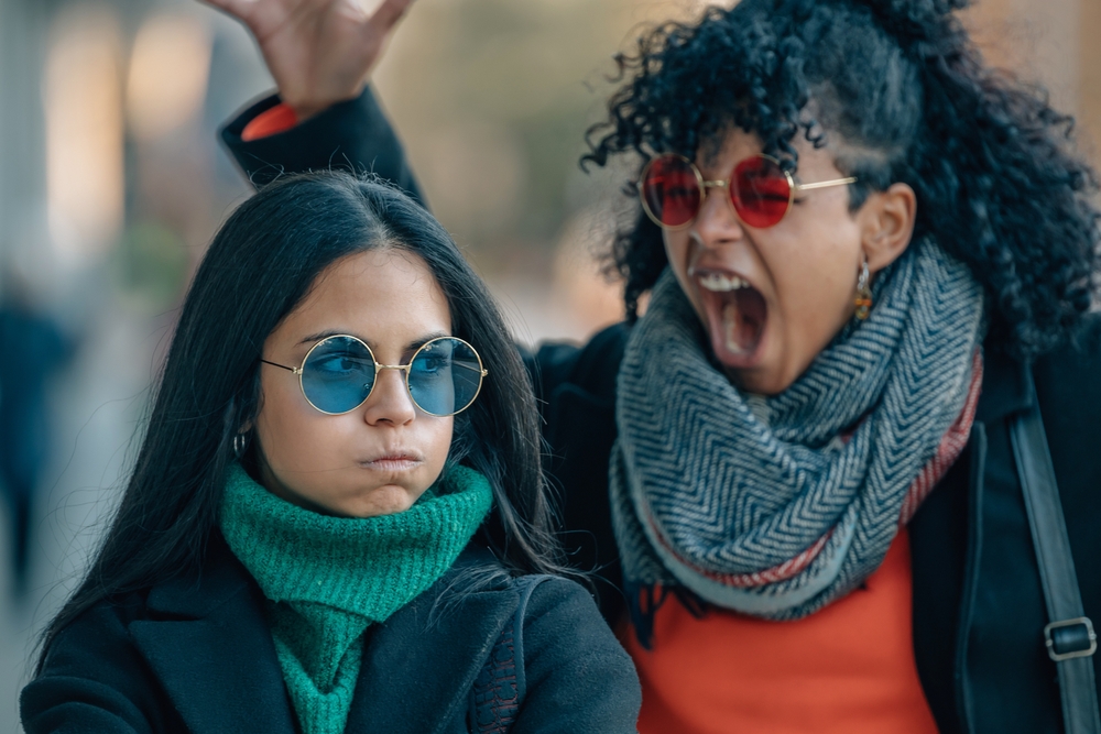An angry woman yelling behind her girlfriend