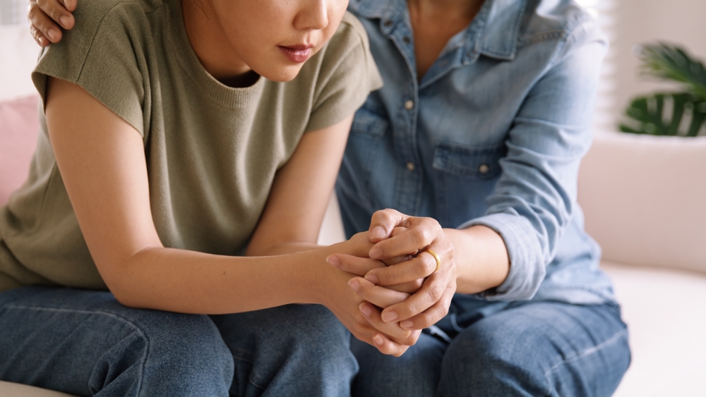 Middle aged woman consoling her young daughter