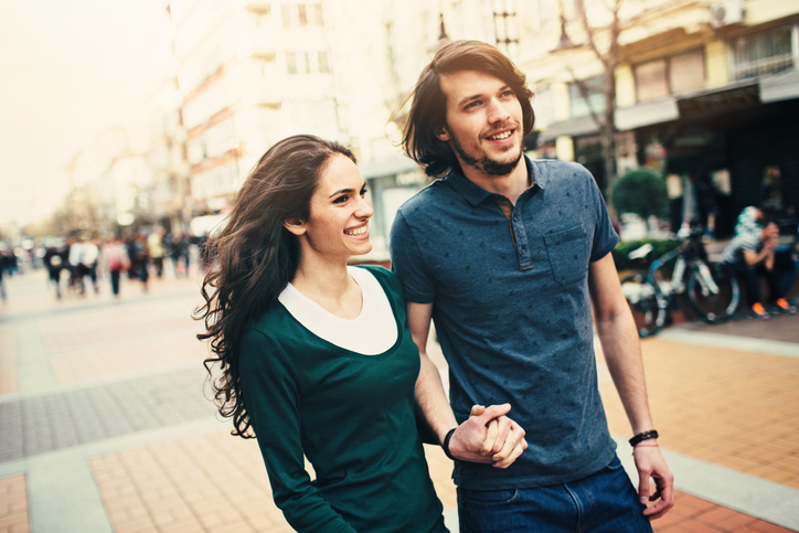 Happy young couple walking and holding hands