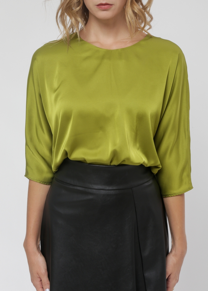 Woman wearing a green silk top.