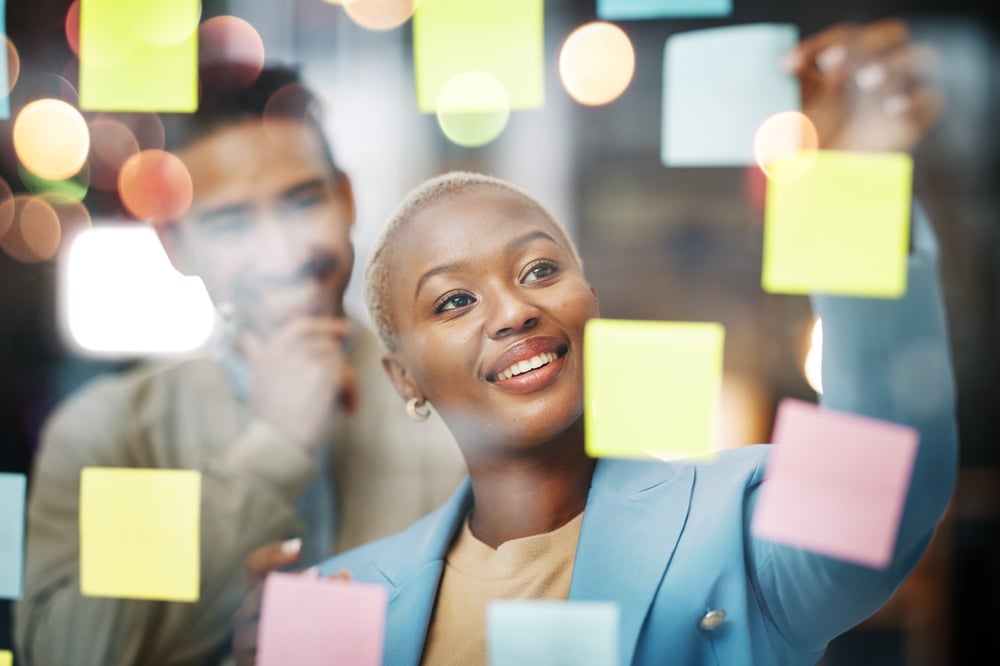 A businesswoman planning and writing on sticky notes