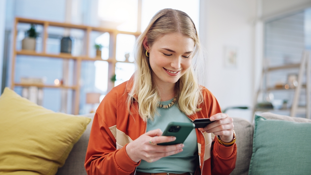 A woman using her credit card to pay for online shopping.