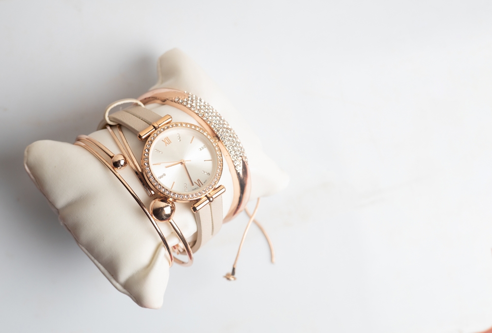Watches and bracelets on a pillow.
