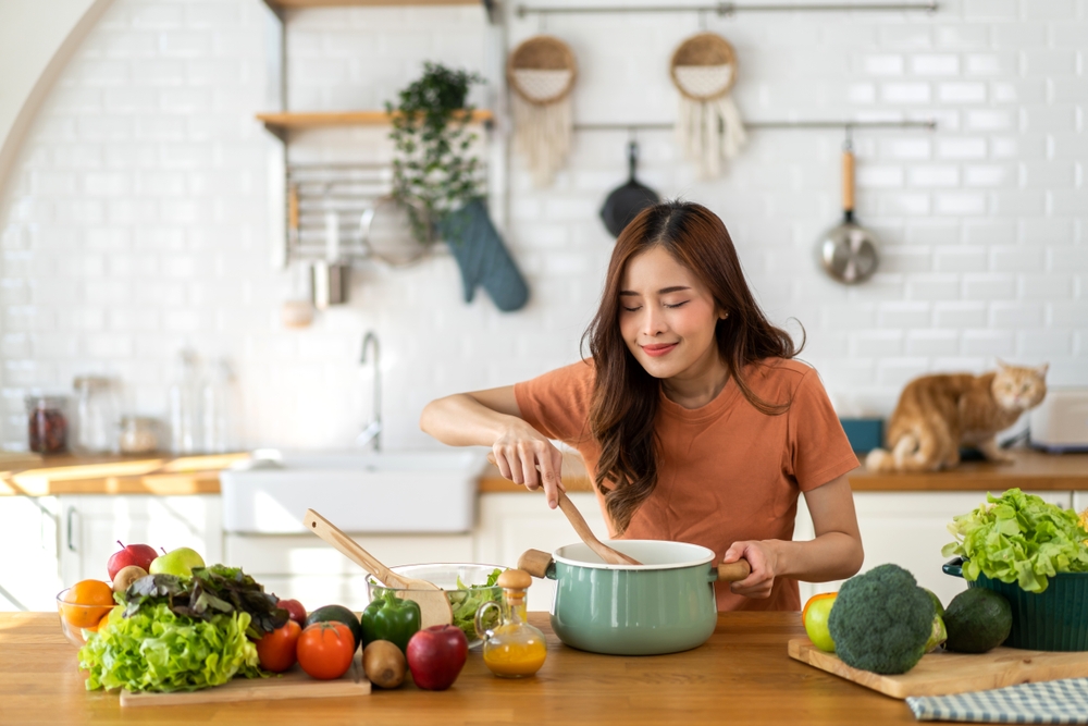Woman stirring a pot while cooking food in the kitchen.