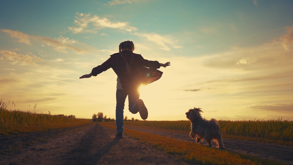 Teenage girl running with her dog.