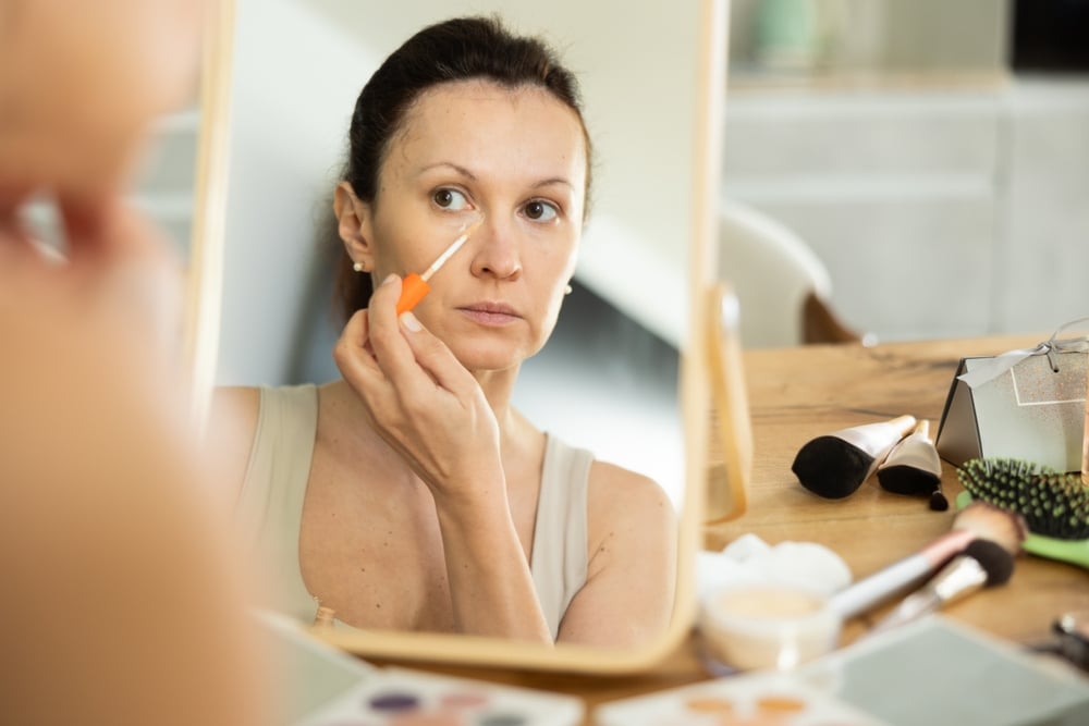 A middle aged woman doing her skin care