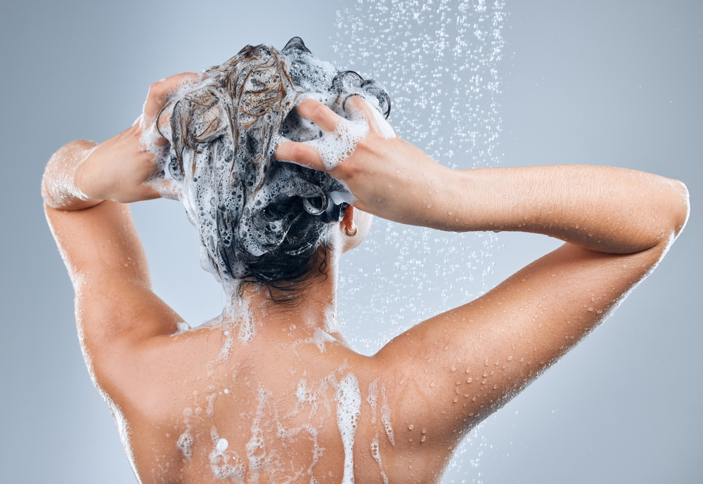 A woman washing her hair in the shower.