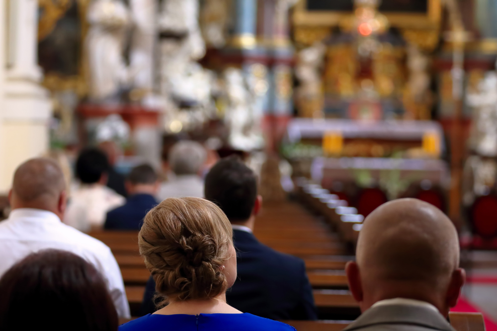 People are sitting on the pews in a church
