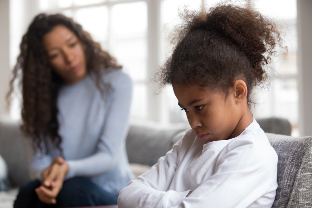 A young mother scolding her young female child
