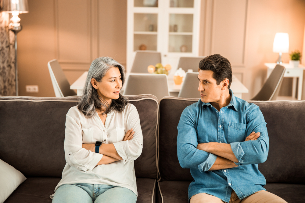 Beautiful middle age woman and handsome man having a quarrel while sitting down