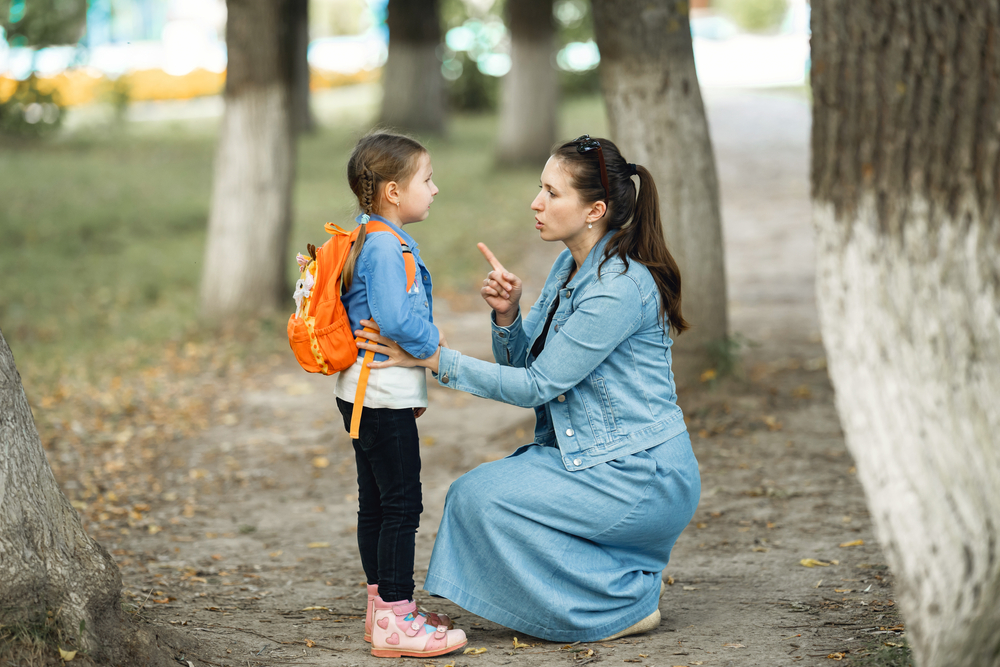 A young mother scolds her young daughter