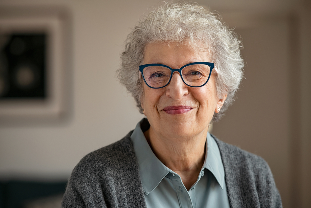 A happy retired senior woman wearing glasses