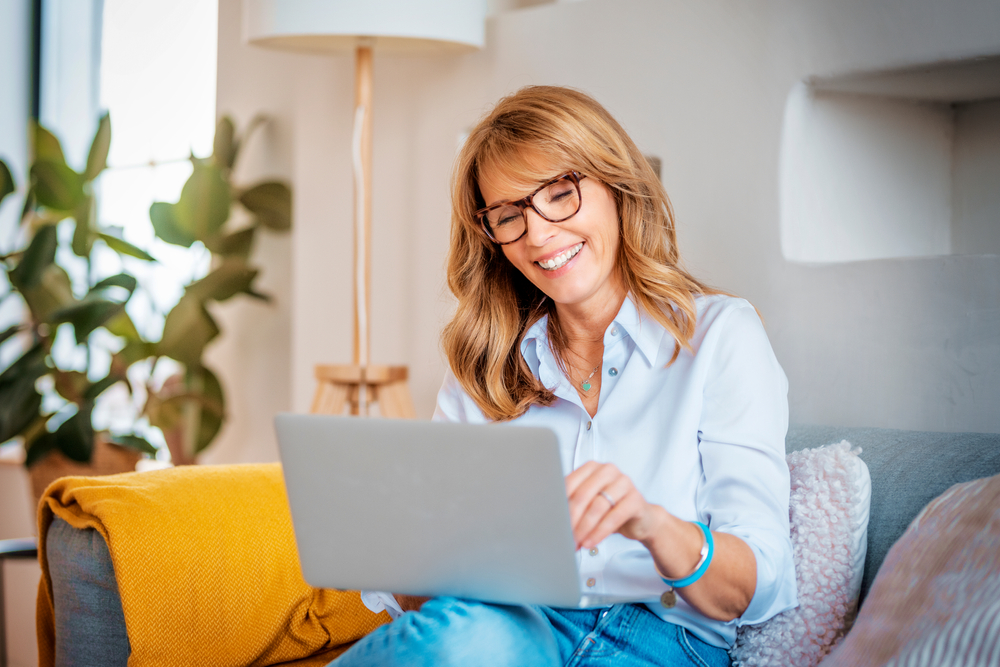 A happy middle aged woman working on her laptop