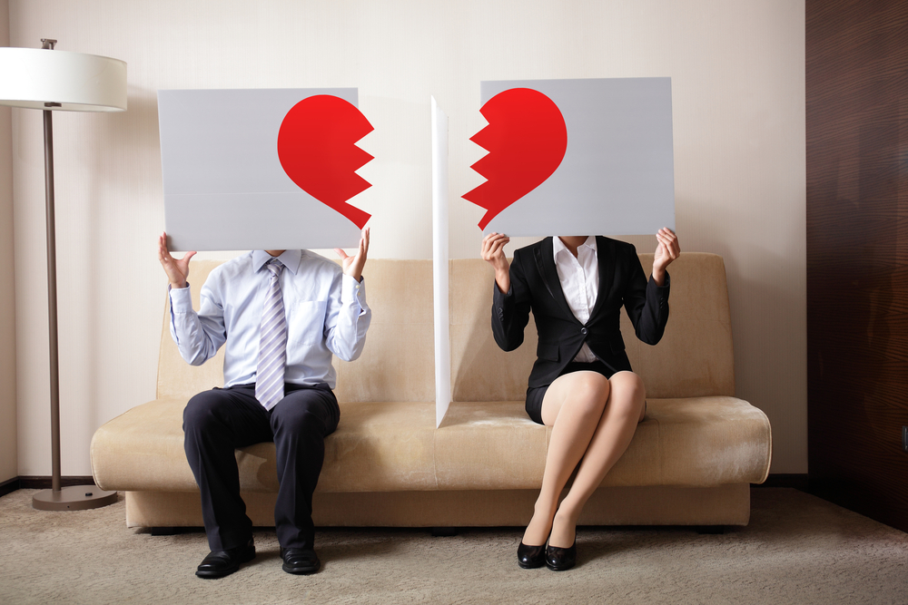 Couple on couch breaking up or getting a divorce.