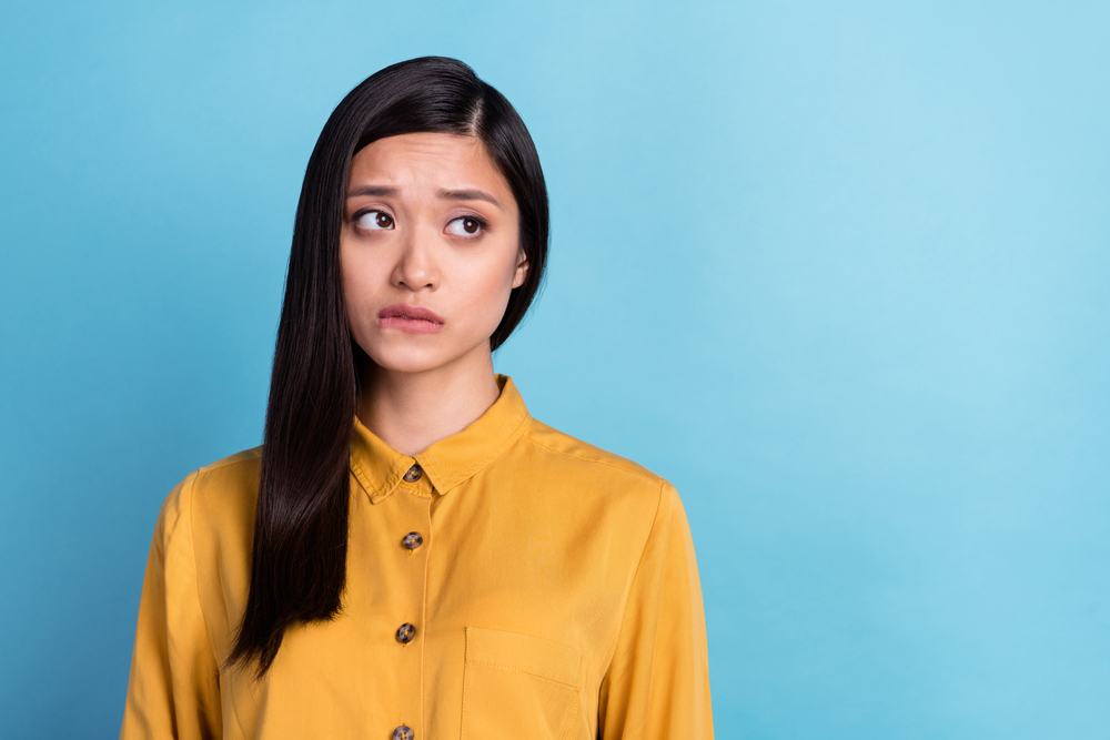Woman bitting her lip looking nervous.