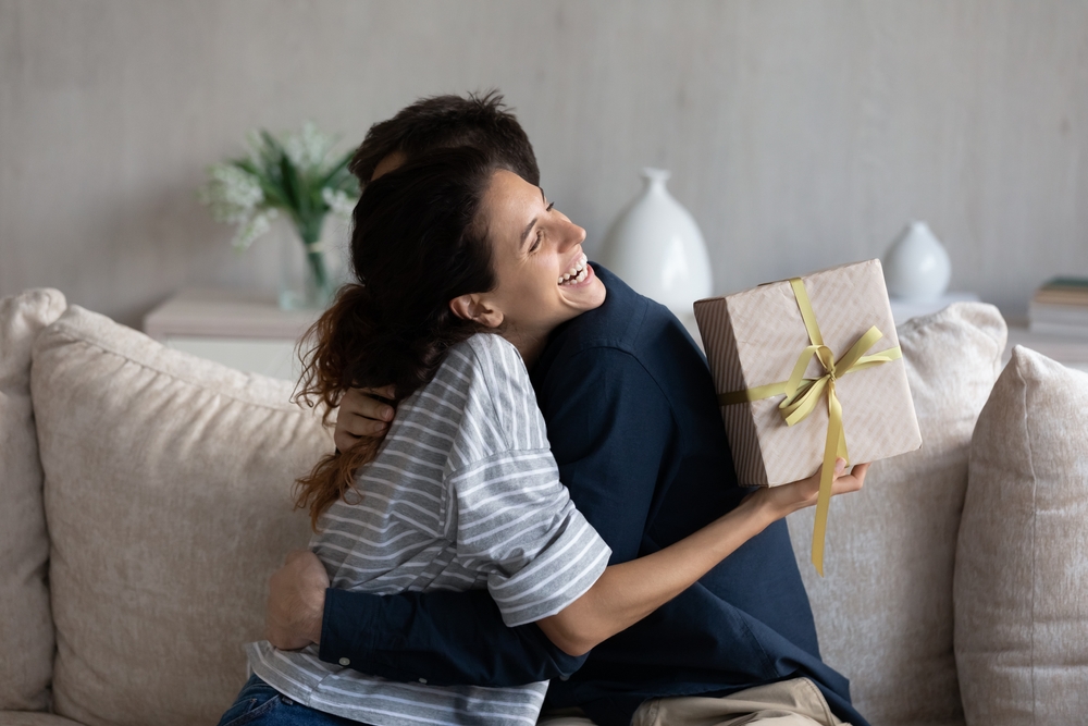 A young woman hugging her lover in gratitude, thankful for her gift