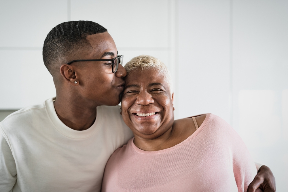 A young adult son with his happy mature senior mother