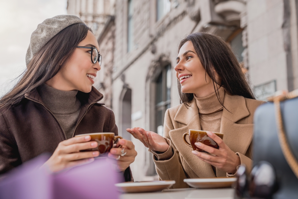 Two young friends and beautiful women having a conversation