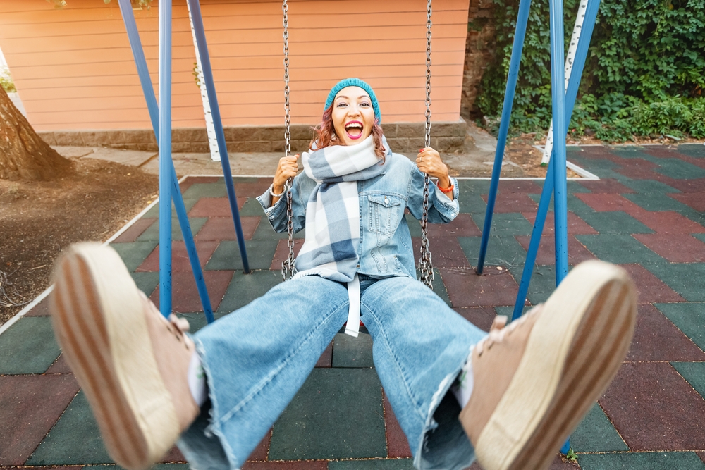 Happy woman on a playground swing with chains