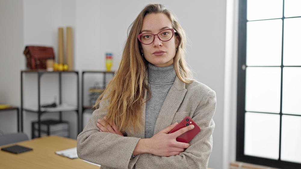 A young caucasian business woman holding her smartphone