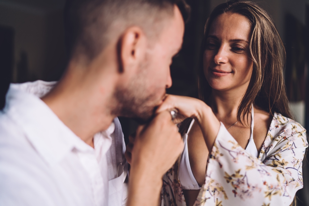 Man kissing his girlfriend's hand.